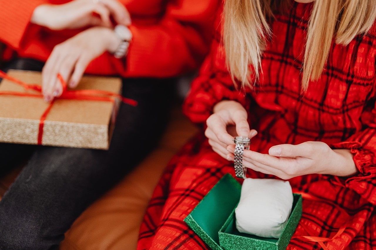 A woman opens a luxury watch gift on Christmas morning.