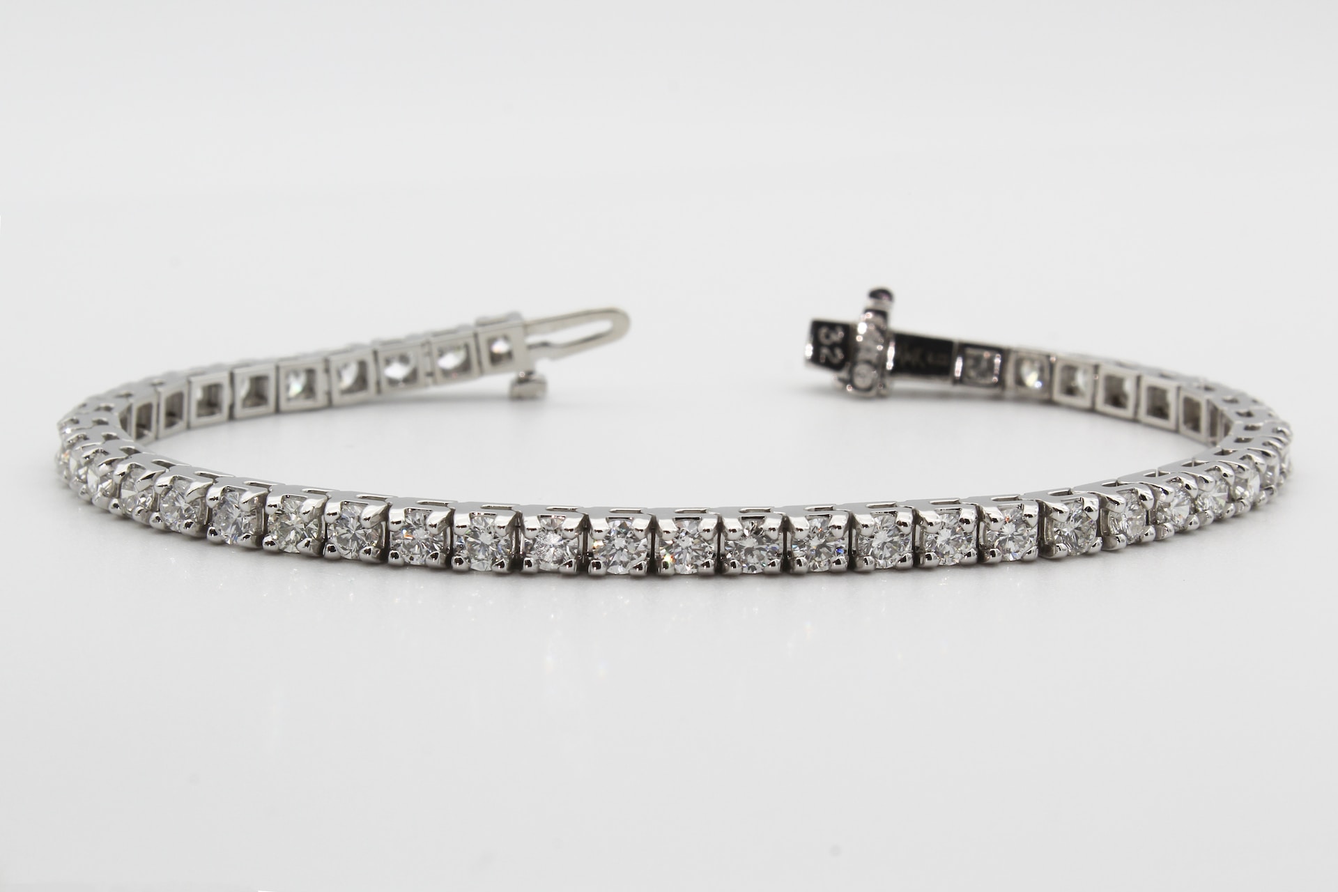 a white gold diamond tennis bracelet on a white background